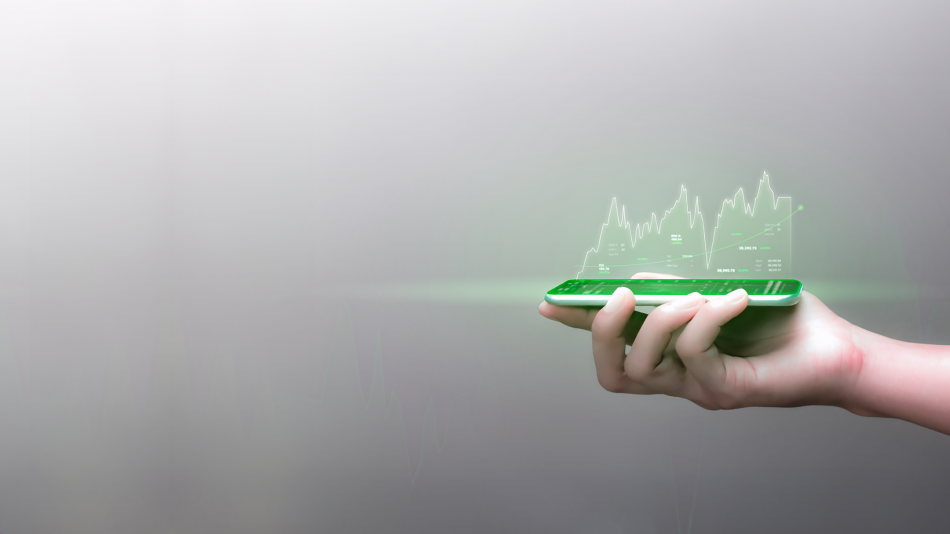 Ręka trzymająca smartphone skierowany ku górze. Ze smartphona bije zielone światło w którym widać wykres liniowy