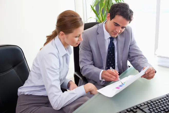Kobieta i mężczyzna w biurze analizują dokument