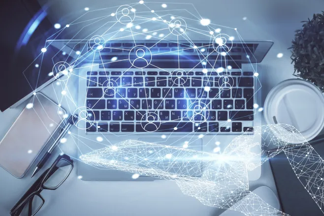 Laptop. Nad klawiaturą widać wizualizację powiązań