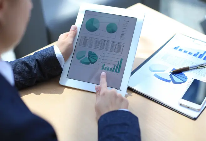 An employee looking at charts on a tablet