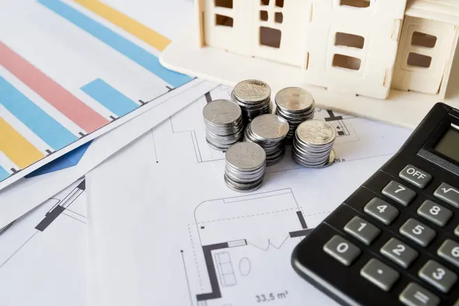 Sheets with charts, columns of coins, and a calculator