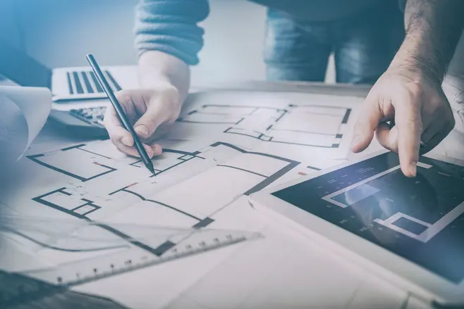 Architekt oglądający plany na papierze i tablecie