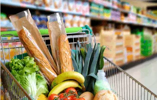 Wózek sklepowy z różnymi produktami spożywczymi.