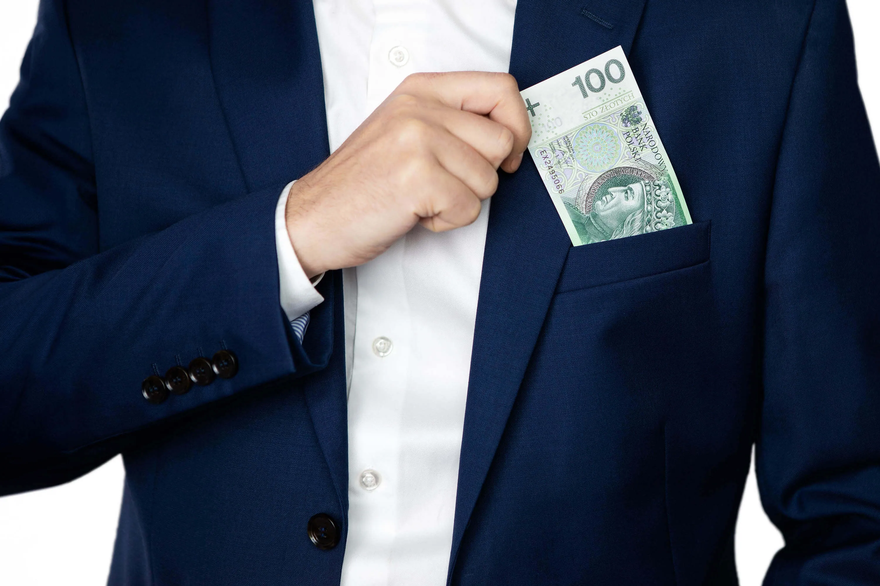 Mężczyzna w garniturze wyjmuje z kieszonki marynarki banknot stuzłotowy