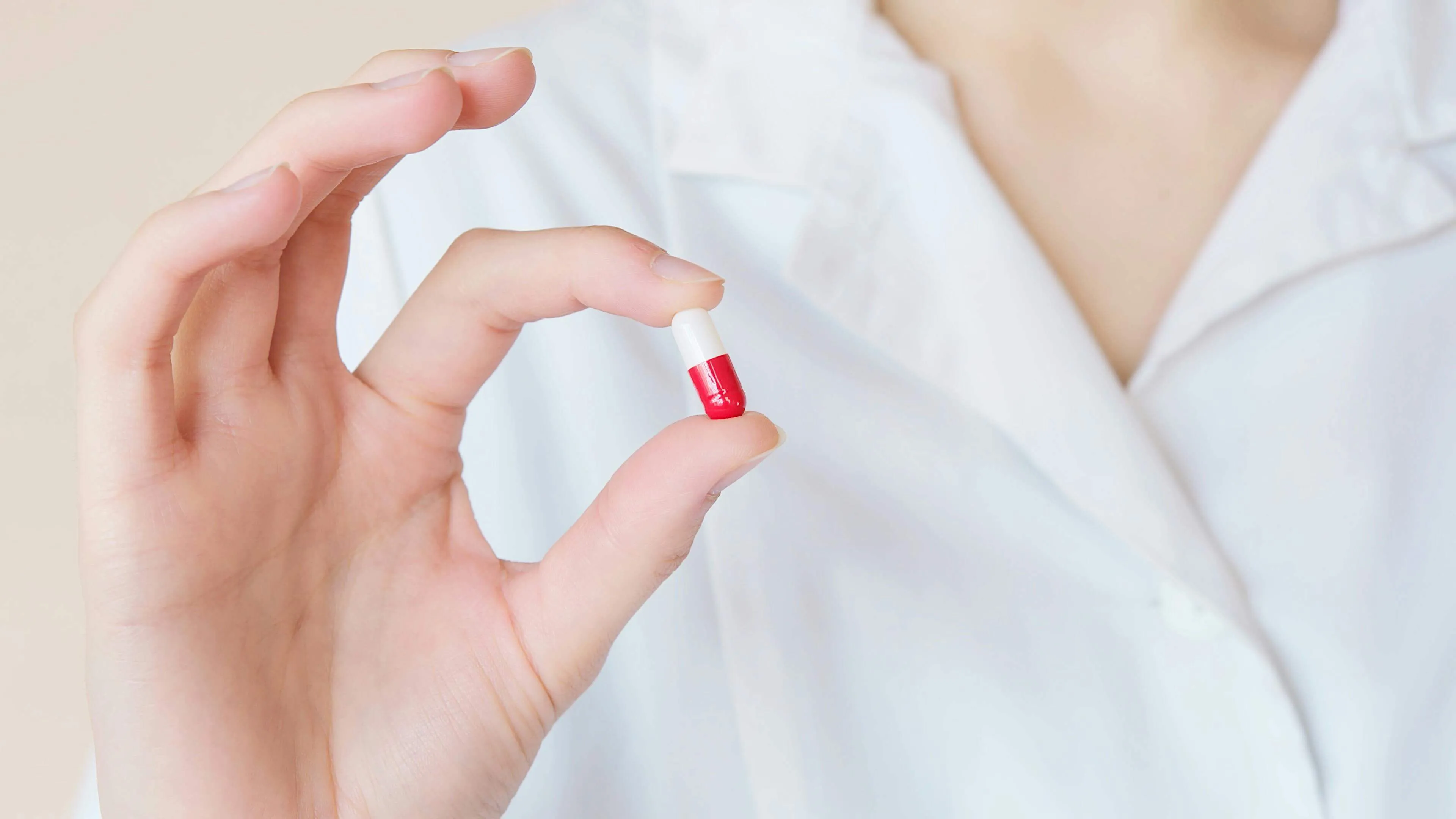 Farmaceuta trzymający w ręku tabletkę